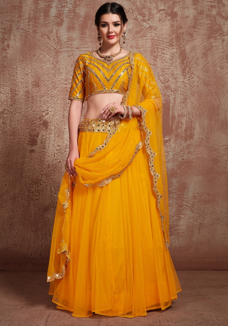Yellow soft silk ceremonial lehenga choli with mirror work blouse