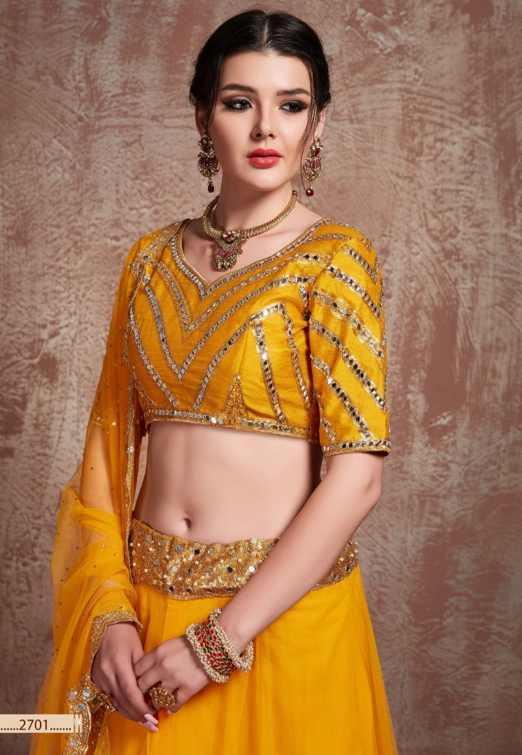 Yellow soft silk ceremonial lehenga choli with mirror work blouse